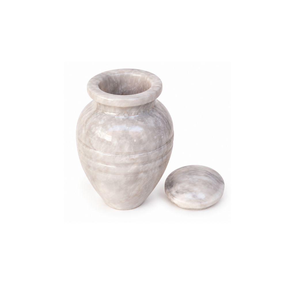 White marble cremation and memorial urn for keeping the ashes of a loved one; Urna funeraria y conmemorativa de mármol blanco para conservar las cenizas de un ser querido; Urna funerária e memorial de mármore branco para guardar as cinzas de um ente querido; Urne funéraire et cinéraire en marbre blanc pour conserver les cendres d’un être cher; Weiße Marmorurne als Gedenkurne zur Aufbewahrung der Asche eines geliebten Menschen; Urna funeraria e commemorativa in marmo bianco per custodire le ceneri di una per