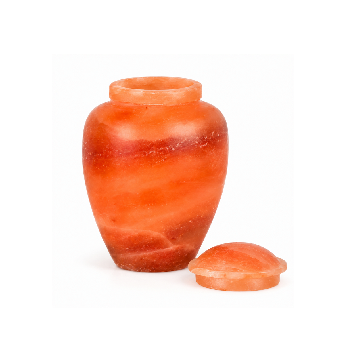 Urna funeraria biodegradable de sal rosa del Himalaya para cenizas humanas, urna ecológica de sal natural con tapa retirada y colocada al lado, diseño artesanal en tonos naranja y rosa, ideal para cremación y entierro natural en agua.